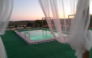 a view of a swimming pool through curtains at Casa Natura in Castro Marim