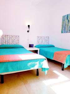 two beds in a white room with blue and green at Apartamento Roymar Levante in Benidorm