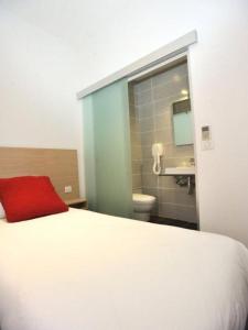una camera con letto e un bagno con lavandino di Hôtel de France a Monte Carlo