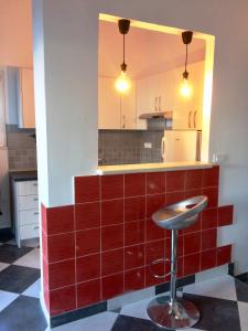 a kitchen with a red tile counter and a stool at Villa Luna in Ražanj