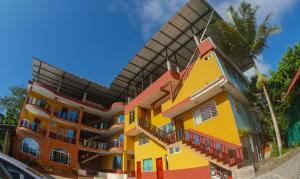 a yellow and orange building with a roof at Hotel Los Bancos in San Miguel de los Bancos