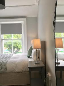 a bedroom with a bed and two lamps and a window at Donnybrook Townhouse in Dublin