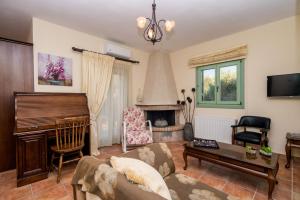 ein Wohnzimmer mit Sofa und Klavier in der Unterkunft Leventis Villas Complex with Sharing Pool in Sparta