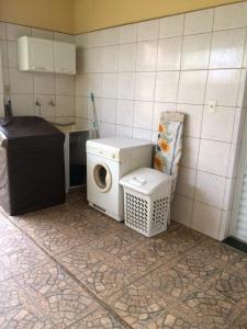 a kitchen with a washing machine and a washer at Casa Familiar em Campinas com 2 Quartos, 1 banheiro, 1 vaga para carro in Campinas