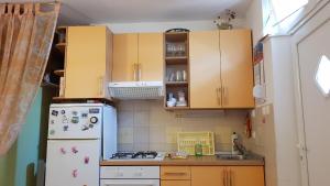 cocina con armarios de madera y nevera en Apartment Barbara, en Novalja