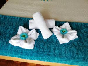 three toilet paper towels and flowers on a table at Casa da Vista Rio in Amora +44 photos
