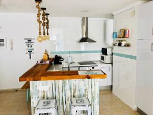 a kitchen with a counter with two stools at Apartamento Ático a 50 metros de la playa Will in Rincón de la Victoria