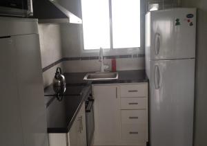 eine Küche mit einem weißen Kühlschrank und einer Spüle in der Unterkunft Alora in Piriápolis + 9 Fotos