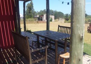 einen Holztisch und Stühle auf einer Veranda in der Unterkunft Alora in Piriápolis