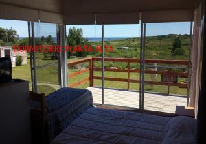 1 Schlafzimmer mit 2 Betten vor einem großen Fenster in der Unterkunft Alora in Piriápolis