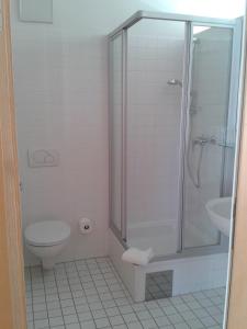 a bathroom with a shower and a toilet and a sink at Haus der Begegnung in Innsbruck