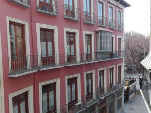 a pink building with windows and balconies at Príncipe C in Granada
