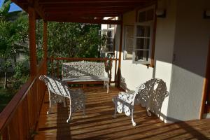 two chairs and a bench on a porch at The Pool House in Saint Philip