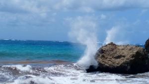 a wave hitting a rock in the ocean at The Pool House in Saint Philip
