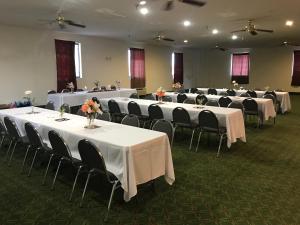 a room with rows of tables and chairs with flowers on them at Pinckneyville Inn and Suites in Pinckneyville +42 photos