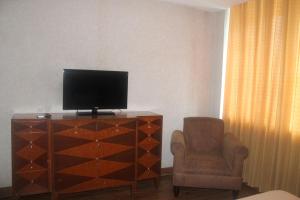 馬尼拉的住宿－馬尼拉珍珠酒店，配有电视、椅子和梳妆台的房间