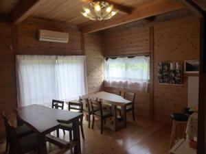 a dining room with tables and chairs in a cabin at Pension Blue Drop in Yakushima