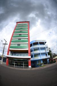 un grand bâtiment avec un bâtiment rouge et vert dans l'établissement Swamy Hotel, à Cruzeiro do Sul