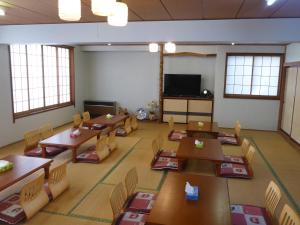 a classroom with tables and chairs and a flat screen tv at Nozawa Dream in Nozawa Onsen