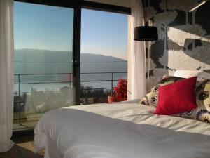 a bedroom with a white bed with a large window at Le Clos Du Lac - location de chambres in Veyrier-du-Lac