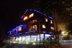 una casa iluminada por la noche con luces azules en Walk Cloud Bed and Breakfast, en Meishan
