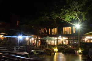 a restaurant with tables and umbrellas at night at Walk Cloud Bed and Breakfast in Meishan