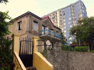 an old house with a staircase in front of a building at Achi Guest House in Makhinjauri
