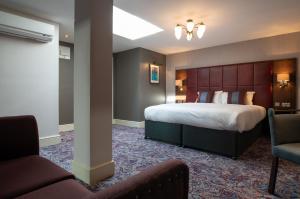 a hotel room with a bed and two chairs at Thomas Ingoldsby Wetherspoon in Canterbury