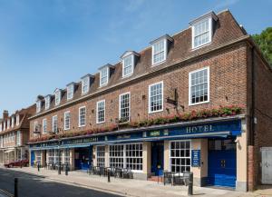 a red brick building with white windows on a street at Thomas Ingoldsby Wetherspoon in Canterbury