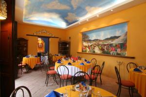 a dining room with tables and chairs and a painting on the wall at Hotel Hacienda Don Cenobio in San Pablo Villa de Mitla