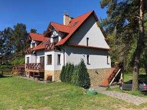 ein großes weißes Haus mit rotem Dach in der Unterkunft Domaszowka in Kąty Rybackie