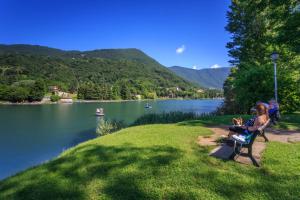 Monasterolo del CastelloにあるCASA VACANZA Residence Lago di Endineの湖畔のベンチに座る人々