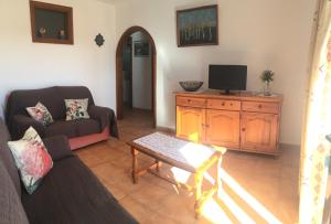 sala de estar con sofá y TV en Casa "GARA" Mala-Lanzarote Norte en Mala