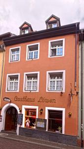 un grand bâtiment orange avec un magasin de Noël dans l'établissement Gasthaus Löwen, à Fribourg-en-Brisgau