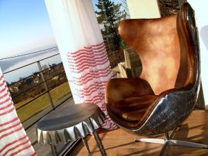 a chair on a balcony with a view of the ocean at Le Clos Du Lac - location de chambres in Veyrier-du-Lac