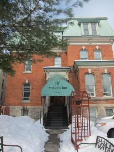 um edifício de tijolos vermelhos com uma placa em frente em McGee's Inn em Ottawa
