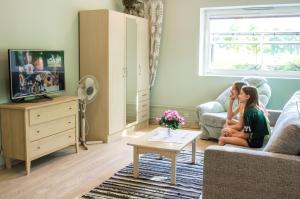 two girls sitting in a living room watching tv at Pärnu Sadama 4 Street Apartment in Pärnu