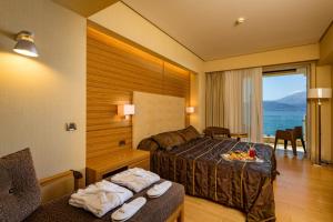 una camera d'albergo con un letto e vista sull'oceano di Nafs Hotel a Nafpaktos