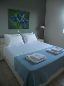 a bed with two towels on top of it at Villa Kampos Paros in Pounda