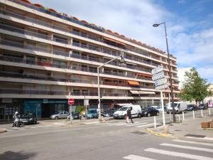 Un gran edificio con coches aparcados en un estacionamiento. en Jardins du Pont du Lys, en Juan-les-Pins