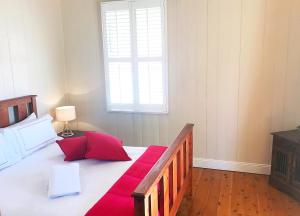 a bedroom with a bed with red pillows and a window at 4 bedroom house - Walk to Southbank in Brisbane