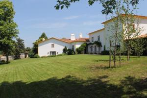 una casa con un gran césped delante de ella en quinta do outeiro, en Vila Nova de Poiares