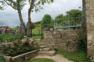 a garden with a stone wall and some flowers at cool la source in Burdignes