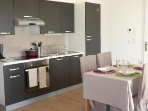 een keuken met een tafel, een wastafel en een fornuis bij La Mariennaye in Beaurepaire +7 foto's