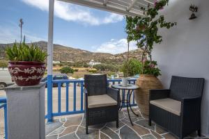 un patio con sedie e un tavolo sul balcone. di Pension Moschoula a Platis Yialos Sifnos