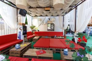 un soggiorno con mobili rossi e tavoli rossi di Vila Sandra a Costinesti