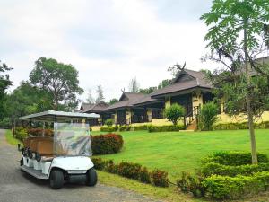 a golf cart parked in front of a house at Doi Inthanon Riverside resort in Chom Thong