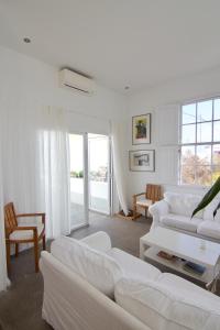 ein weißes Wohnzimmer mit weißen Möbeln und Fenstern in der Unterkunft Casa La Breña in Breña Baja