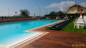 una grande piscina con sedie e tavoli e un tavolo con sedie di Camping Ali Baba a Ceriale