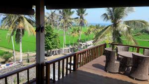 a balcony with a view of the ocean and palm trees at Kirra's Beach House in Pulukan